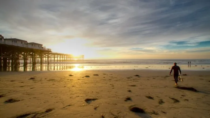 A Surfer walks to the Ocean at Pacific Beach, San Diego