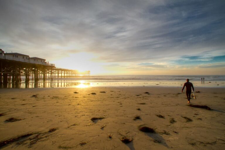 A Surfer walks to the Ocean at Pacific Beach, San Diego