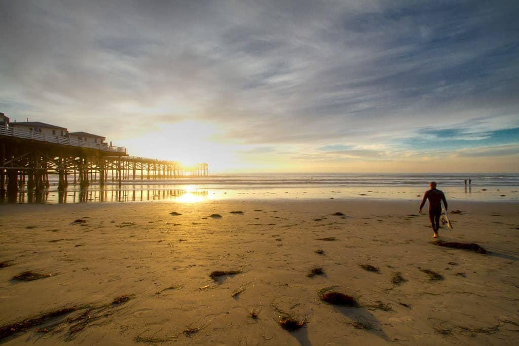 A Surfer walks to the Ocean at Pacific Beach, San Diego